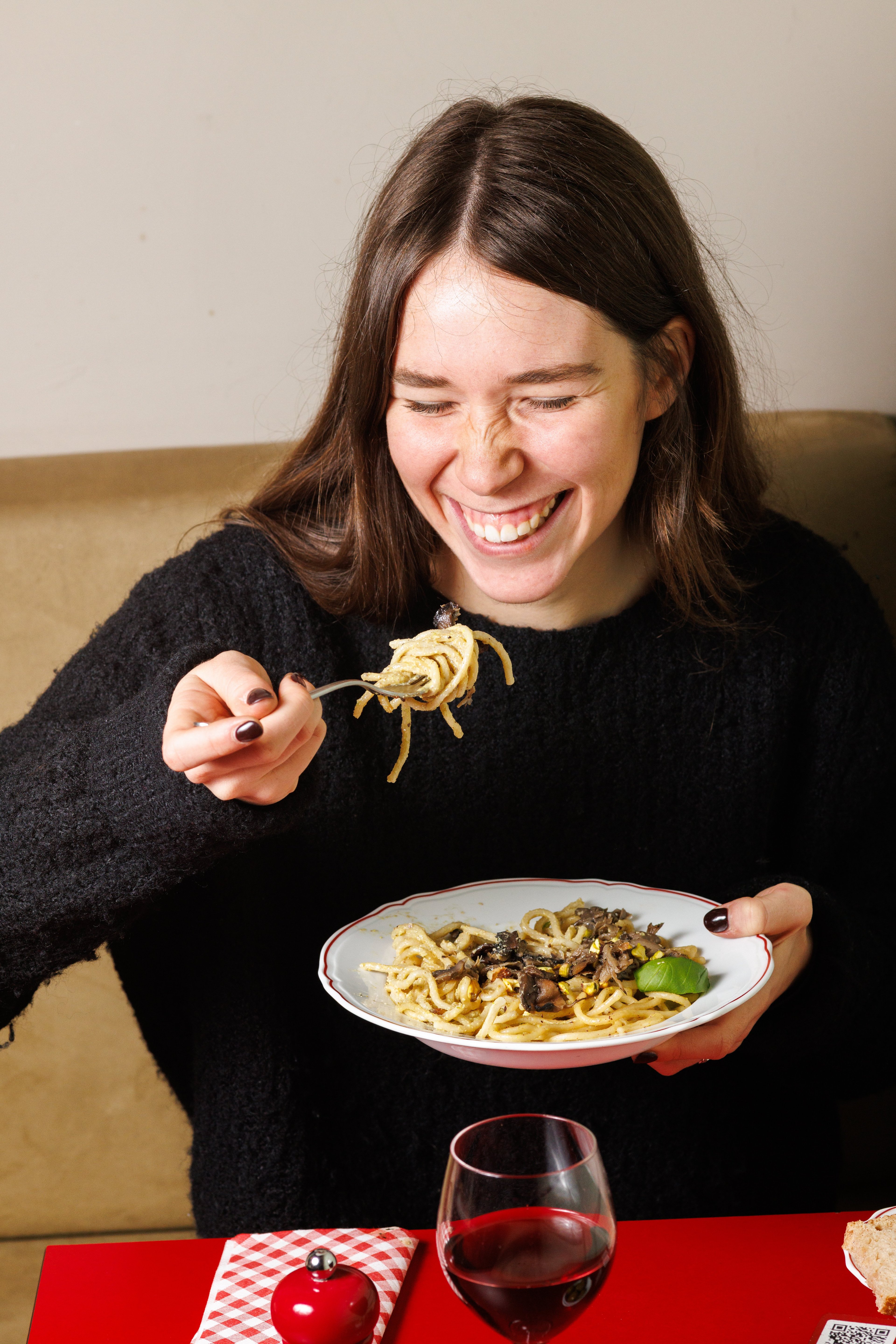 cliente  felice che mangia spaghetti pistacchio e funghi